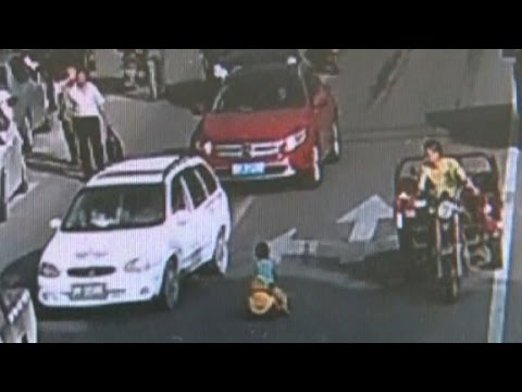 boy rides toy car into rush hour traffic