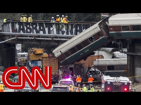 derailed amtrak train dangles over highway