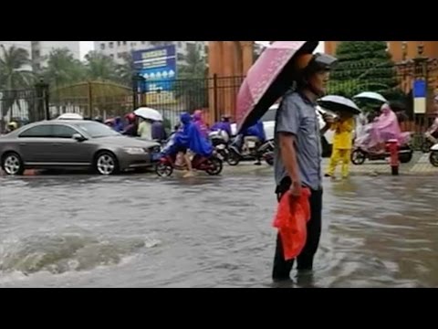 good samaritan guards manhole during a storm in hainan province