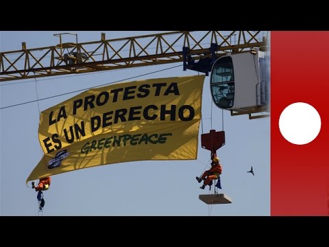 greenpeace activists scale crane near spanish congress